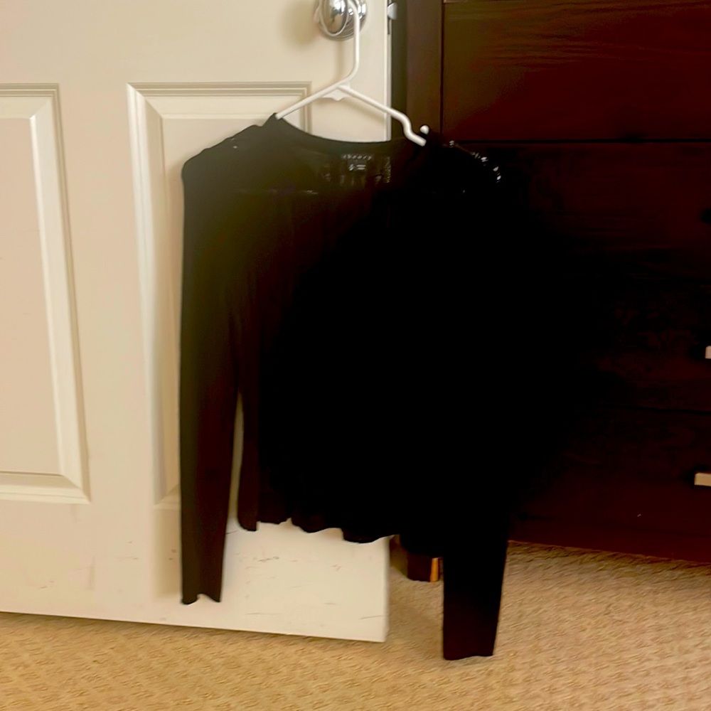 Black sweater, comes to top of jeans pants with extra long sleeves